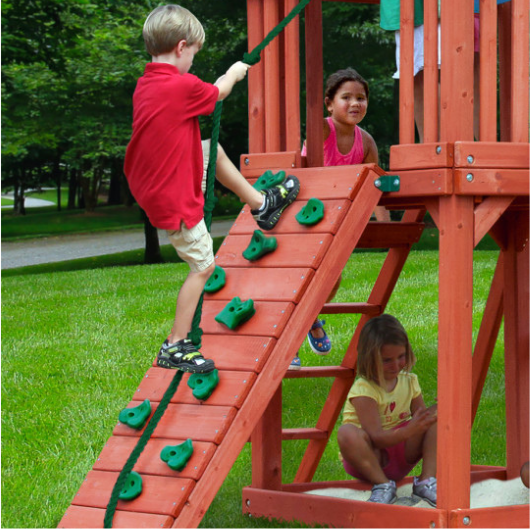 Boy climbing gorilla rock climbing wall with rope